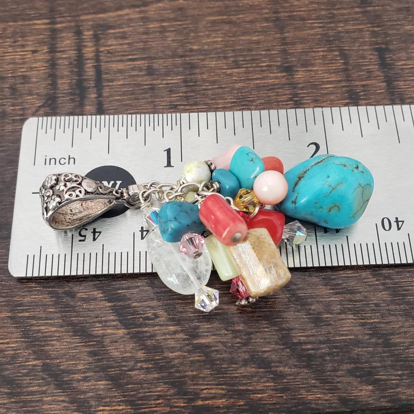 Multi-stone cluster pendant with floral design bail.