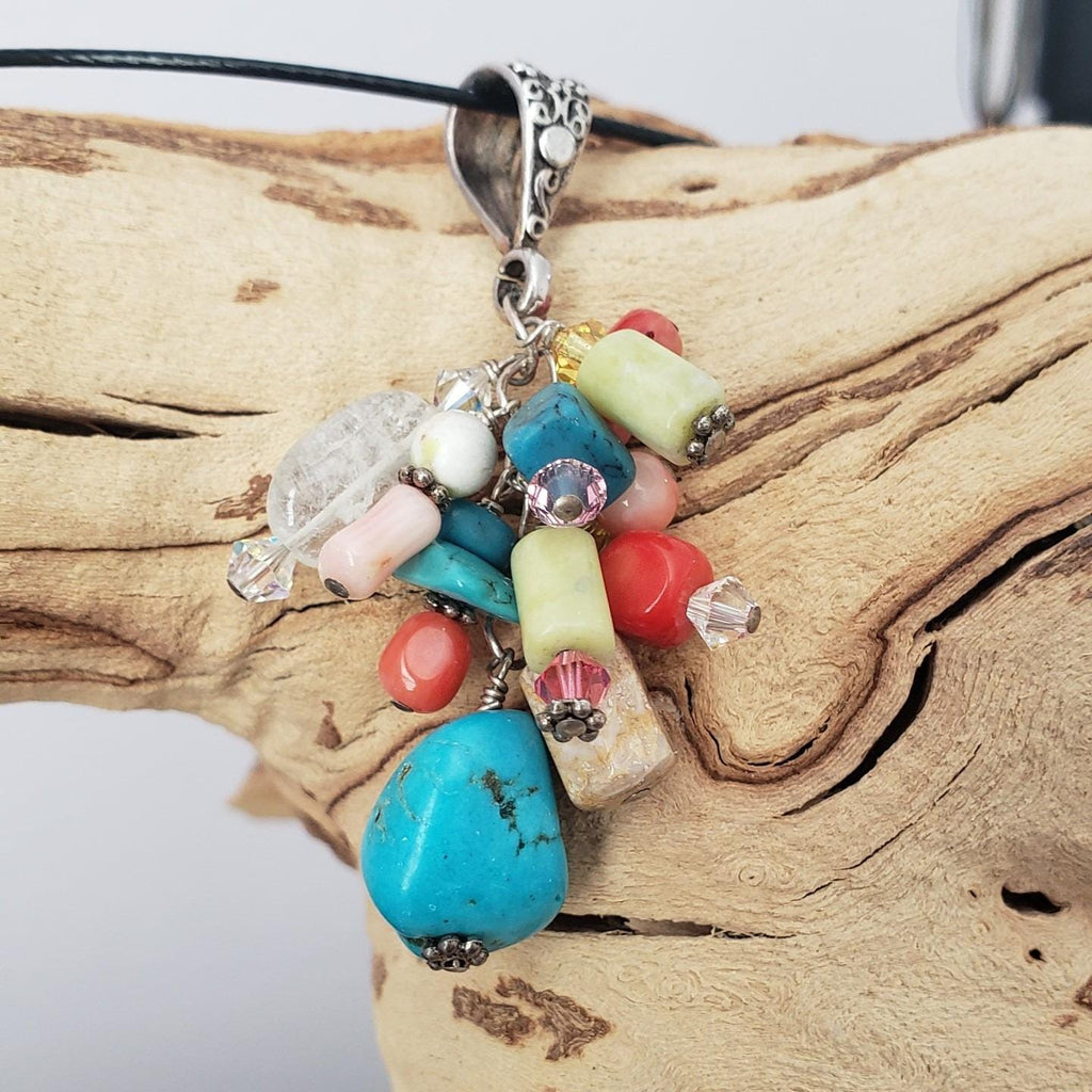 Multi-stone cluster pendant with floral design bail.
