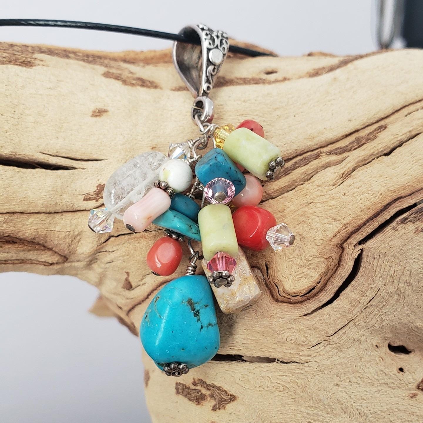 Multi-stone cluster pendant with floral design bail.