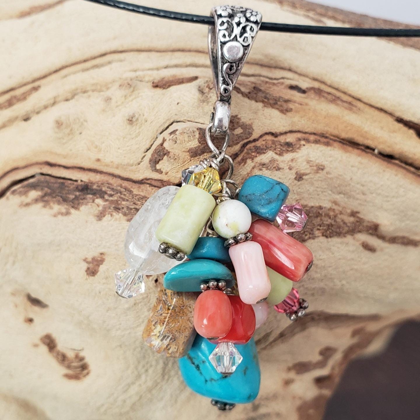 Multi-stone cluster pendant with floral design bail.
