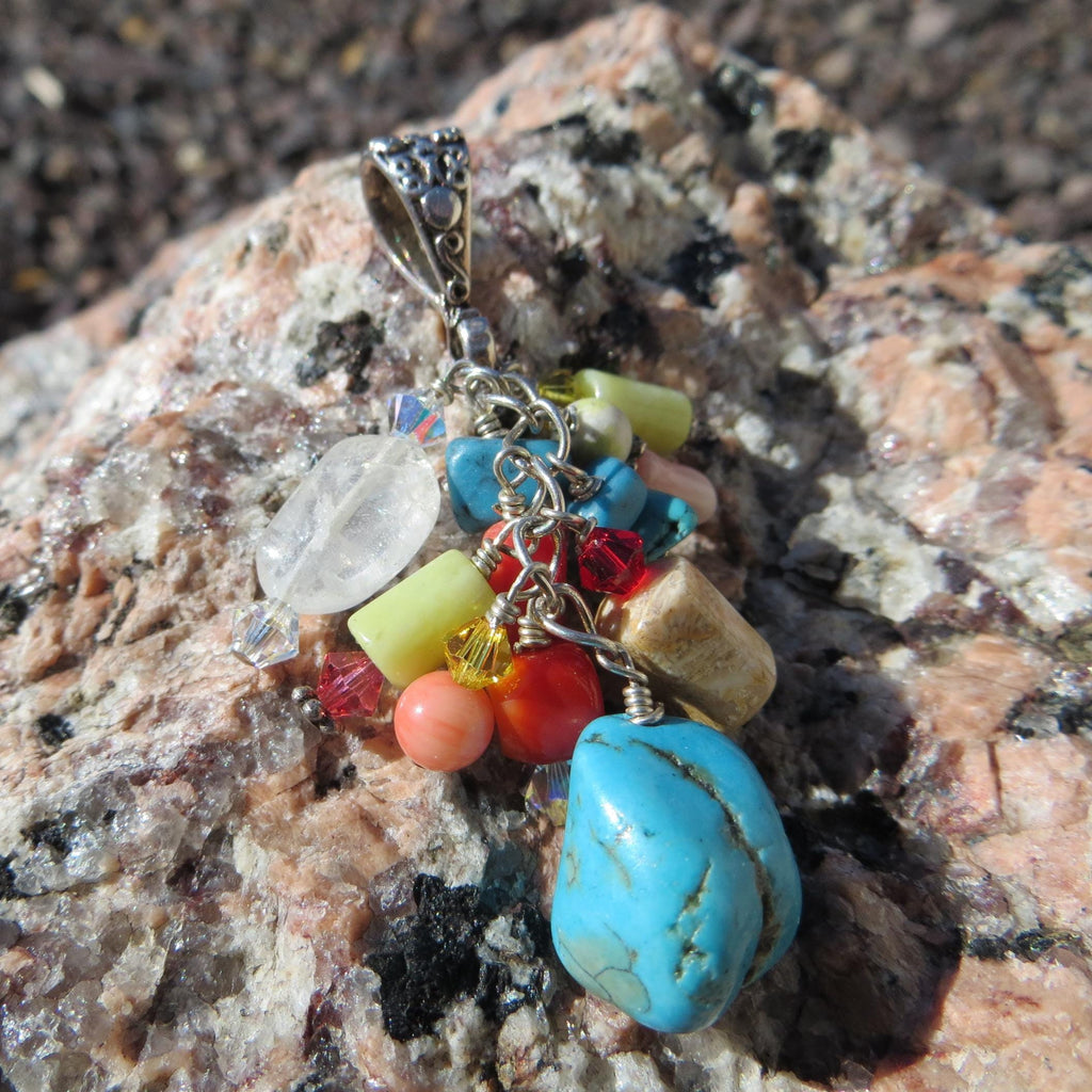 Multi-stone cluster pendant with floral design bail.