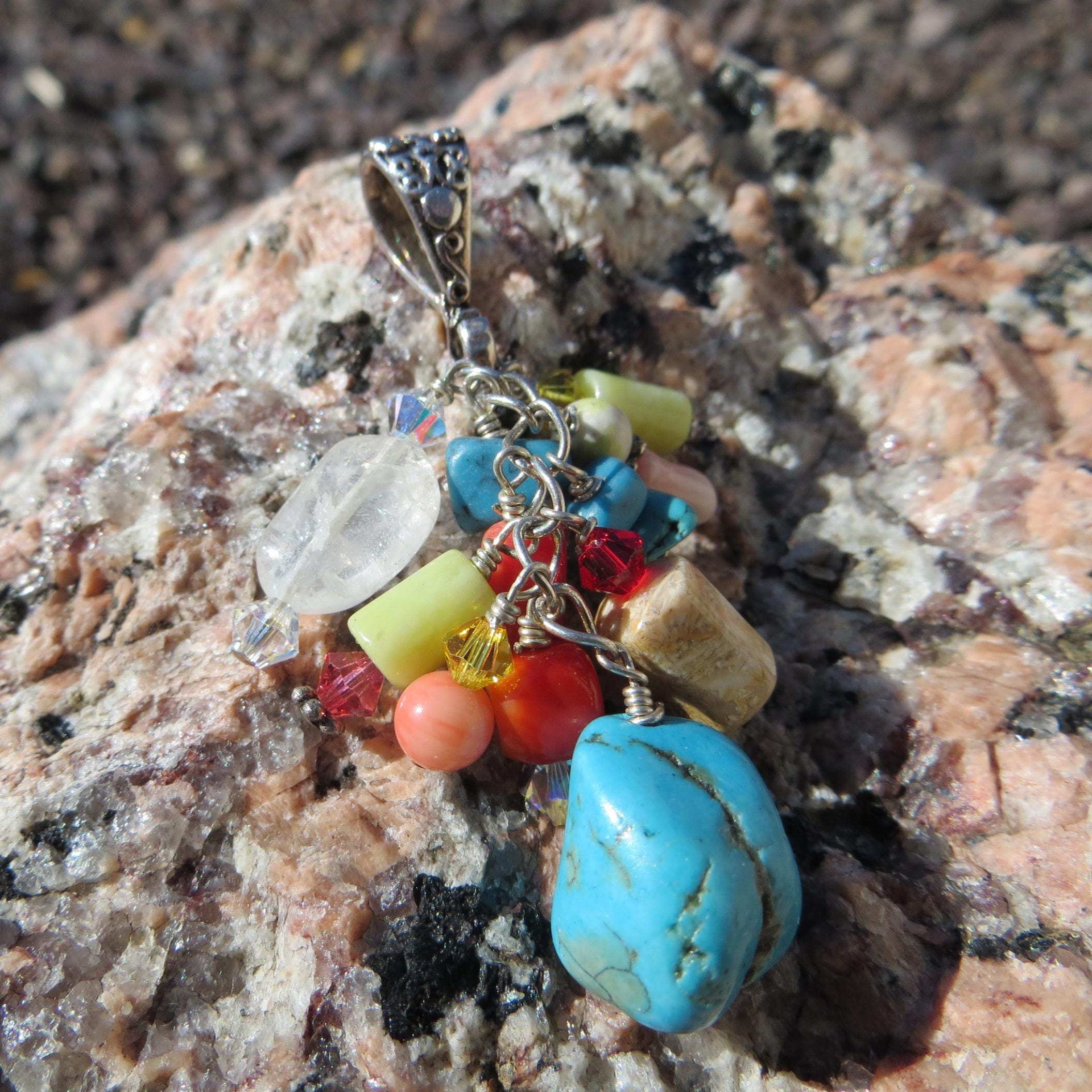 Multi-stone cluster pendant with floral design bail.