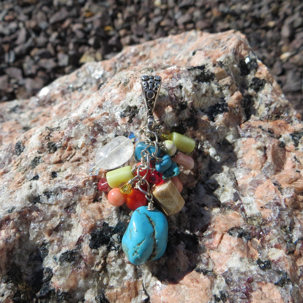 Multi-stone cluster pendant with floral design bail.